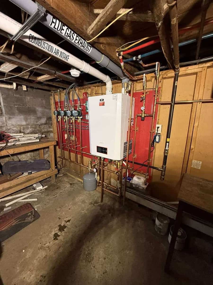 Wall-hung condensing boiler with copper piping, gauges and shutoff valves serviced by Precision Plumbing Solutions