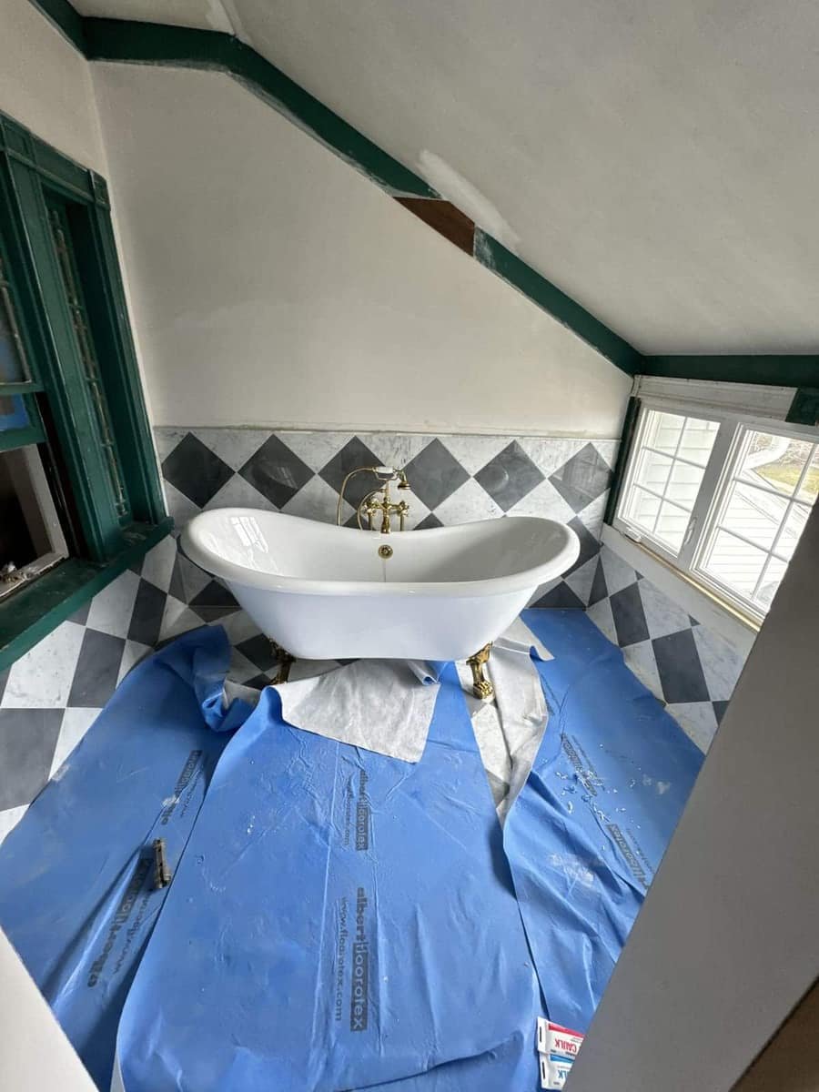 Clawfoot tub supply lines on a checkered floor — Precision Plumbing Solutions