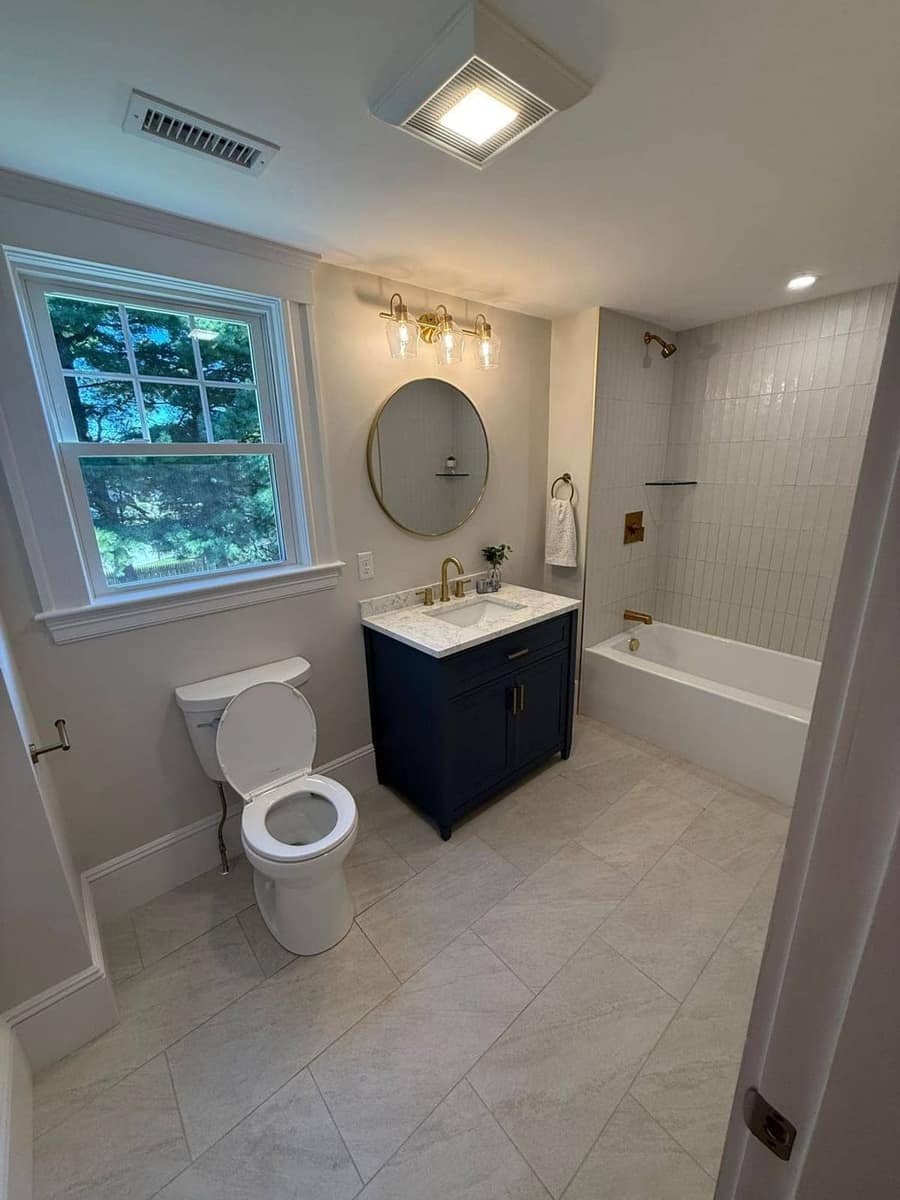 Navy vanity, tub and toilet — finish plumbing — Precision Plumbing Solutions