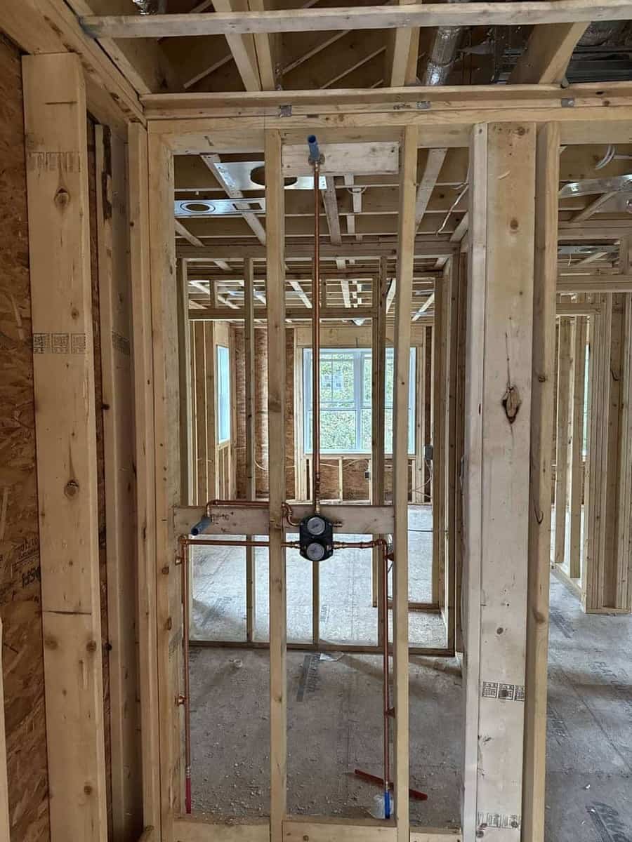 Rough-in plumbing lines run through new construction framing by Precision Plumbing Solutions