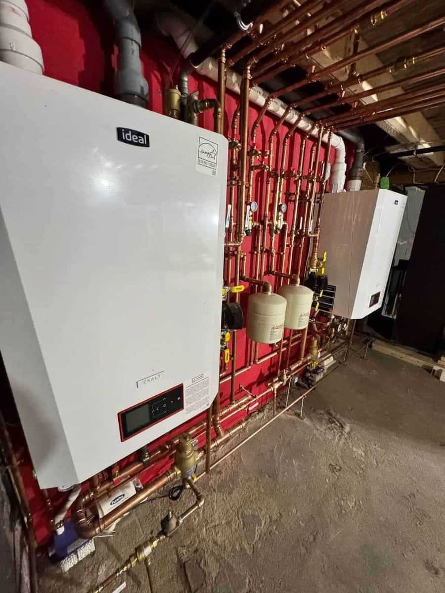 Wall-hung gas boiler with new red and copper piping serviced by Precision Plumbing Solutions in a Lynnfield-area basement
